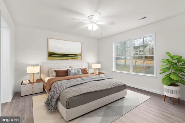 a spacious bedroom with a bed and potted plant