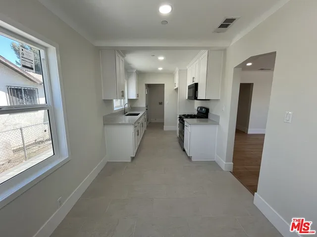 a view of a kitchen with furniture and wooden floor
