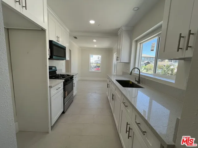 a large kitchen with a large window and stainless steel appliances