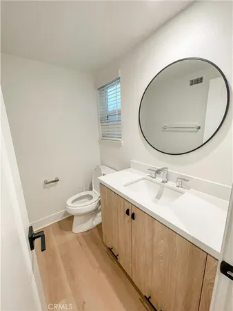 a bathroom with a granite countertop sink toilet a mirror and vanity