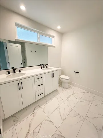 a spacious bathroom with a toilet sink and mirror