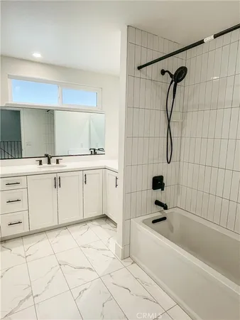 a bathroom with a bathtub sink and mirror