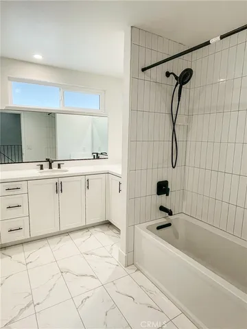 a bathroom with a bathtub sink and mirror