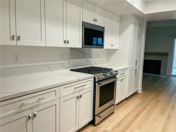 a kitchen with granite countertop white cabinets and white appliances