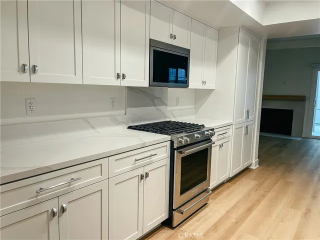 a kitchen with granite countertop white cabinets and white appliances