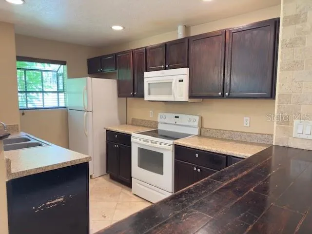 a kitchen with wooden cabinets and white stainless steel appliances