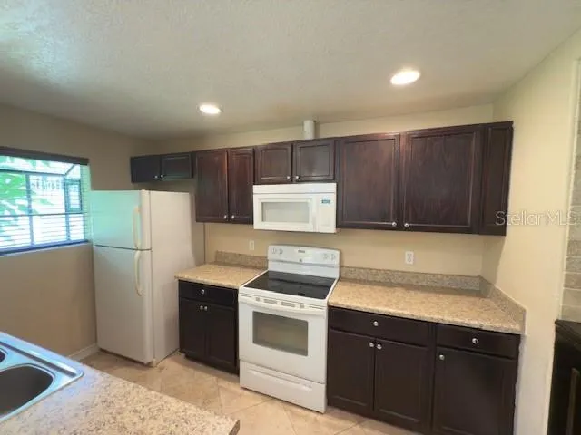 a kitchen with stainless steel appliances granite countertop a refrigerator sink and cabinets