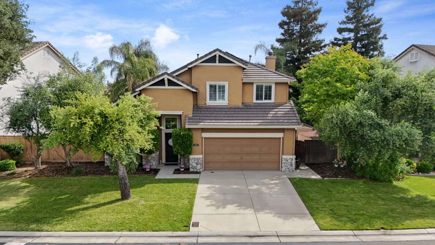 a front view of a house with a yard and trees