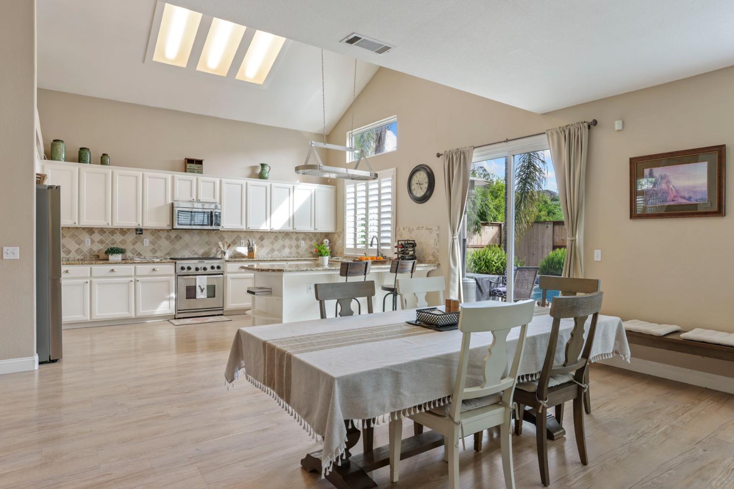 3755 Canyonlands Road Stockton, CA 95209 - Photo 12 of 37 a kitchen with a table chairs a sink dishwasher stove and cabinets with wooden floor