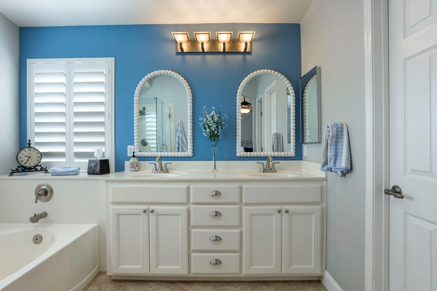 3755 Canyonlands Road Stockton, CA 95209 - Photo 24 of 37 a bathroom with double vanity a mirror two sinks and a bathtub