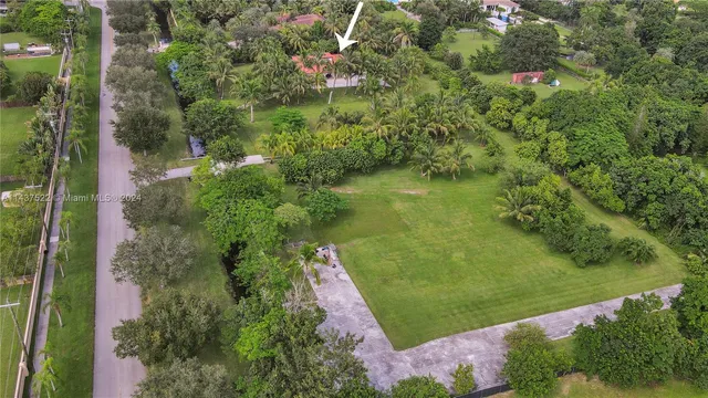 an aerial view of residential house with outdoor space and trees all around