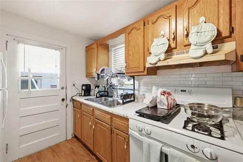 a kitchen with stainless steel appliances a sink a stove and a window