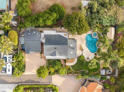 an aerial view of a house with a yard and large trees