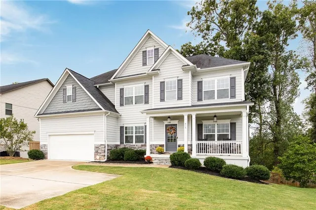a front view of a house with a yard and potted plants
