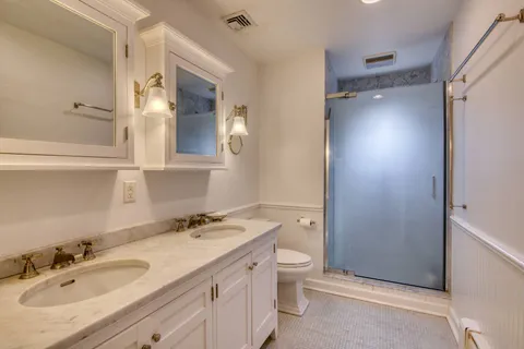 a bathroom with a granite countertop sink toilet and shower