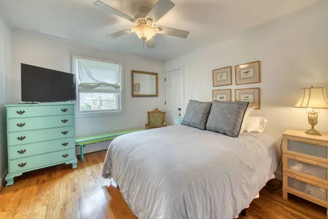 a bedroom with a bed and a flat tv screen on dresser