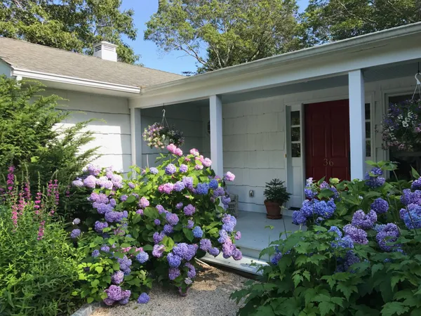 a backyard of a house with lots of green space and outdoor seating