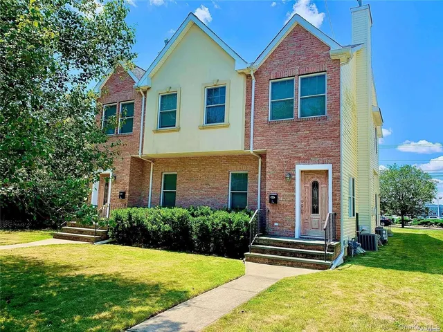 a front view of a house with yard and green space