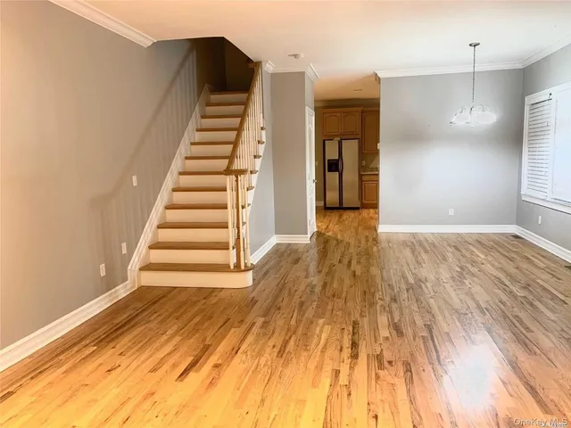 a view of a hallway with wooden floor and stairs