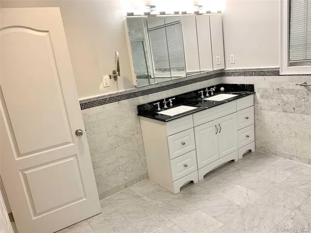a kitchen with white cabinets and sink