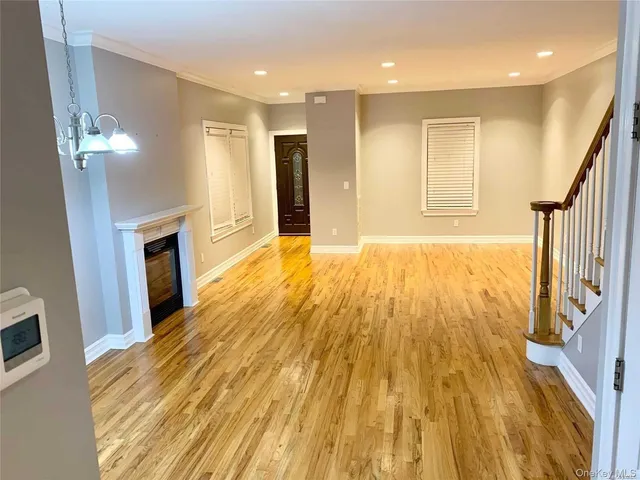 a view of empty room with wooden floor and fireplace
