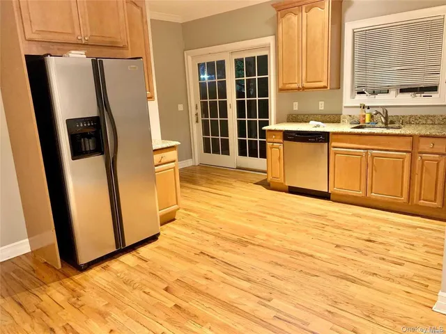 a view of a kitchen with wooden floor and electronic appliances