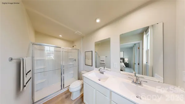 a bathroom with a double vanity sink toilet mirror and shower
