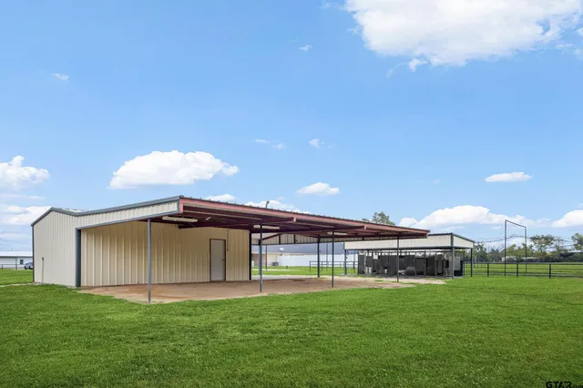 a view of a big house with a big yard and large trees