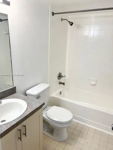 a bathroom with a granite countertop toilet a sink and a bathtub