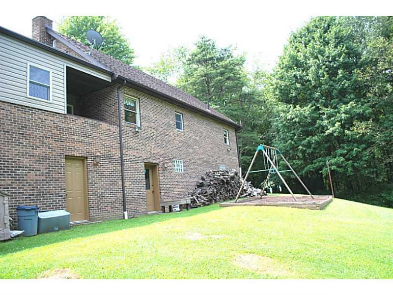141 Sportsman Lane Rochester, PA 15074 - Photo 22 of 25 Exterior Back. Walk out lower level, both from garage and lower level family room! Swing set is permanently cemented in the ground for stability! Lots of wood for your woodstove! *covered patio off kitchen-perfect place for the grill!