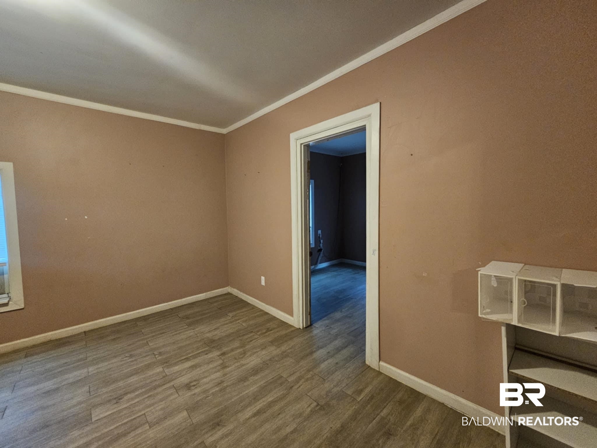 31398 Brady Road Robertsdale, AL 36567 - Photo 13 of 17 Empty room featuring baseboards, crown molding, and wood finished floors