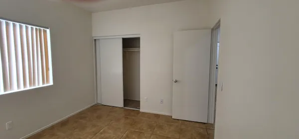 a view of an empty room with windows and closet