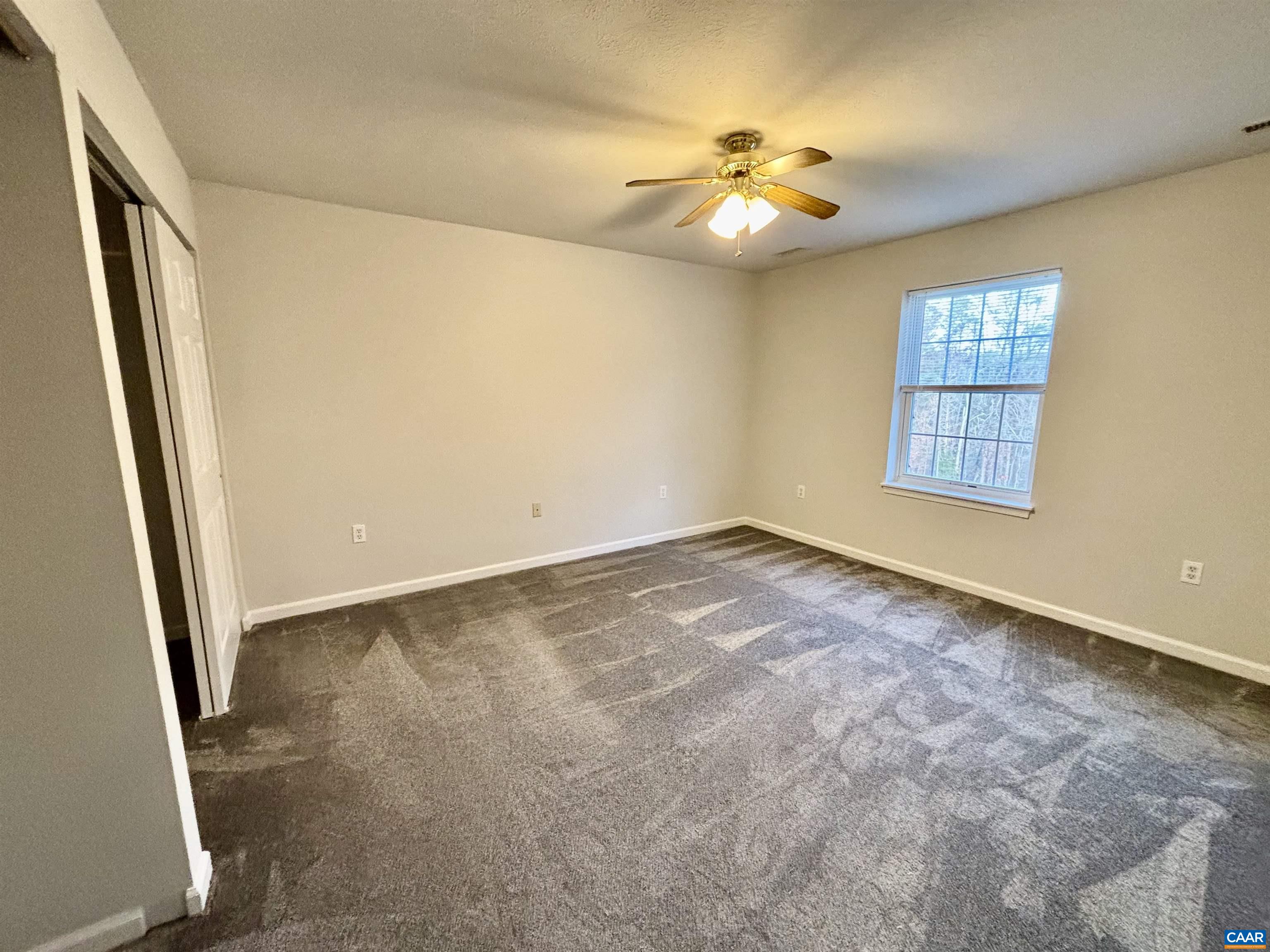 460 Twinkling Springs Road Greenwood, VA 22943 - Photo 11 of 14 an empty room with windows and chandelier fan