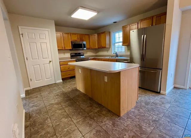 a kitchen with stainless steel appliances granite countertop a refrigerator stove and sink