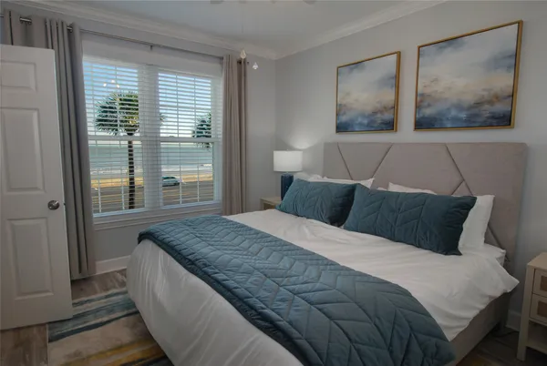 a bedroom with a bed and wooden floor