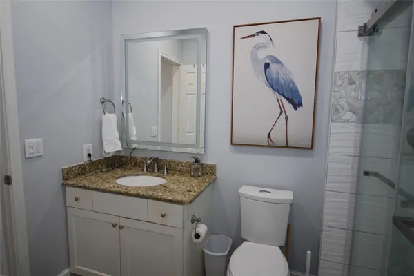a bathroom with a granite countertop sink toilet and shower