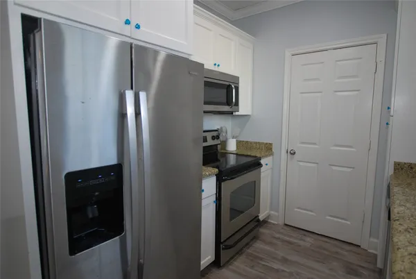 a kitchen with stainless steel appliances granite countertop a refrigerator and a stove top oven