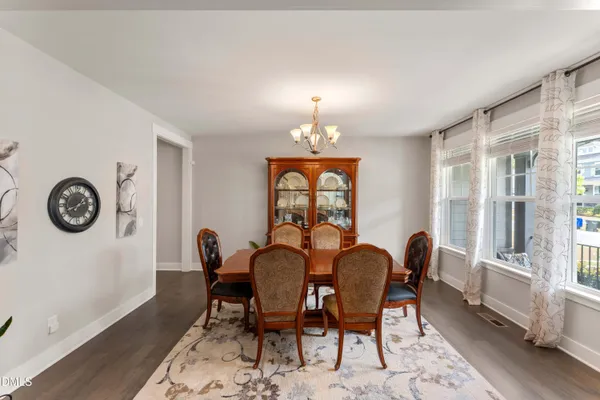 a dining room with furniture a potted plant and wooden floor