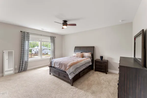 a bedroom with a large bed and a chandelier