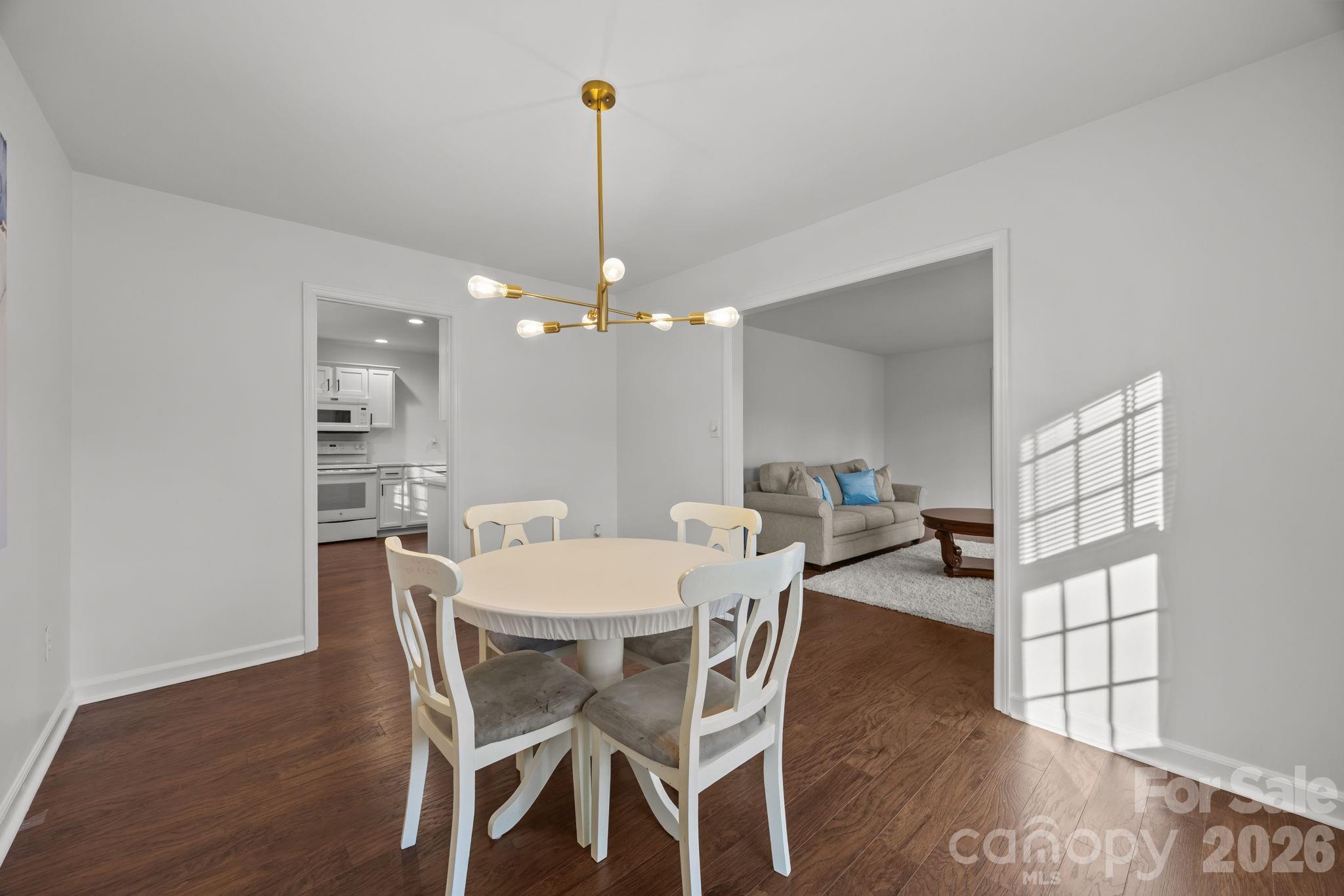 2431 Fox Hollow Road Mint Hill, NC 28227 - Photo 12 of 30 a view of a dining room and livingroom with furniture wooden floor a rug a chandelier