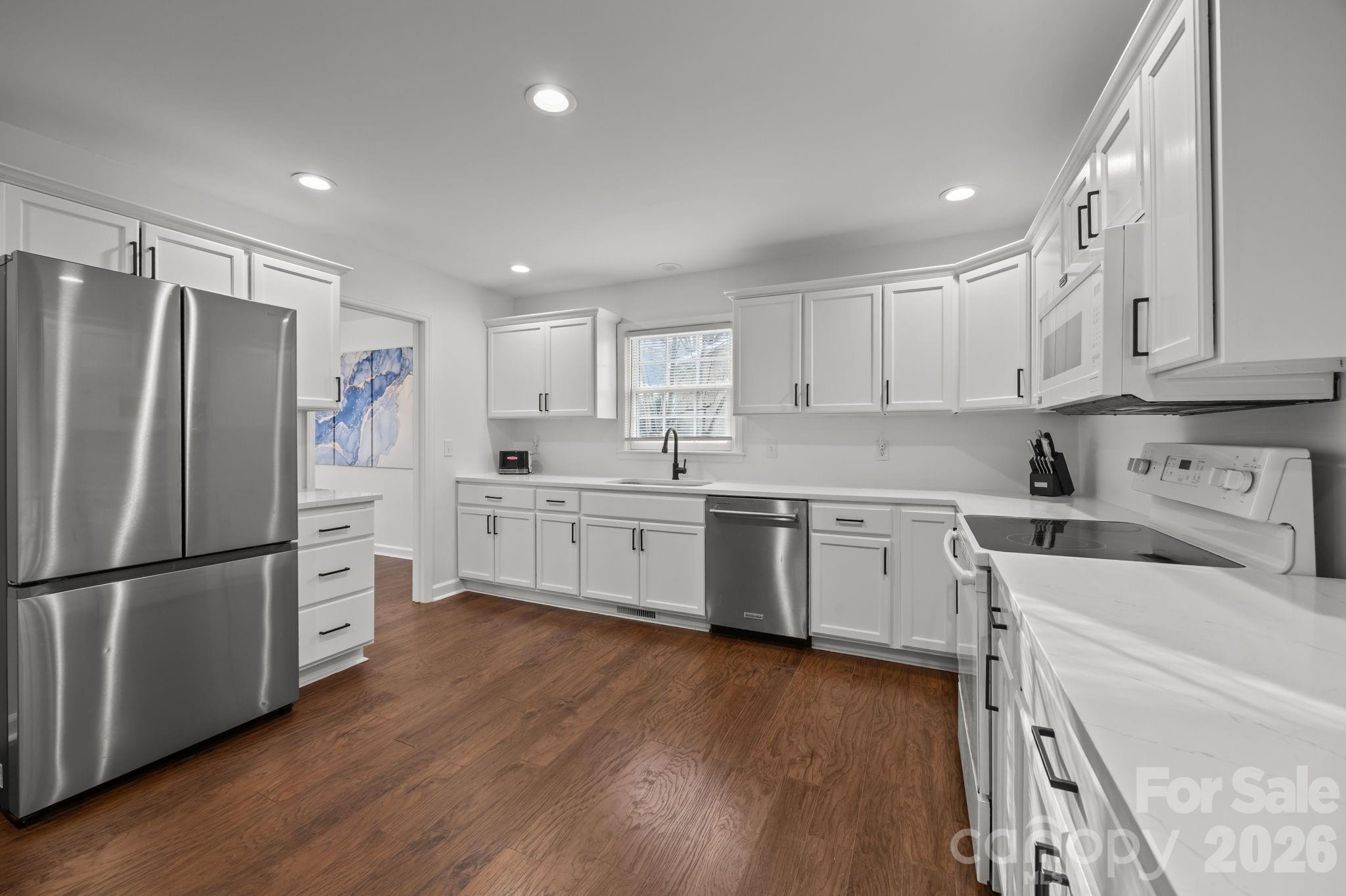 2431 Fox Hollow Road Mint Hill, NC 28227 - Photo 8 of 30 a kitchen with white cabinets and white stainless steel appliances