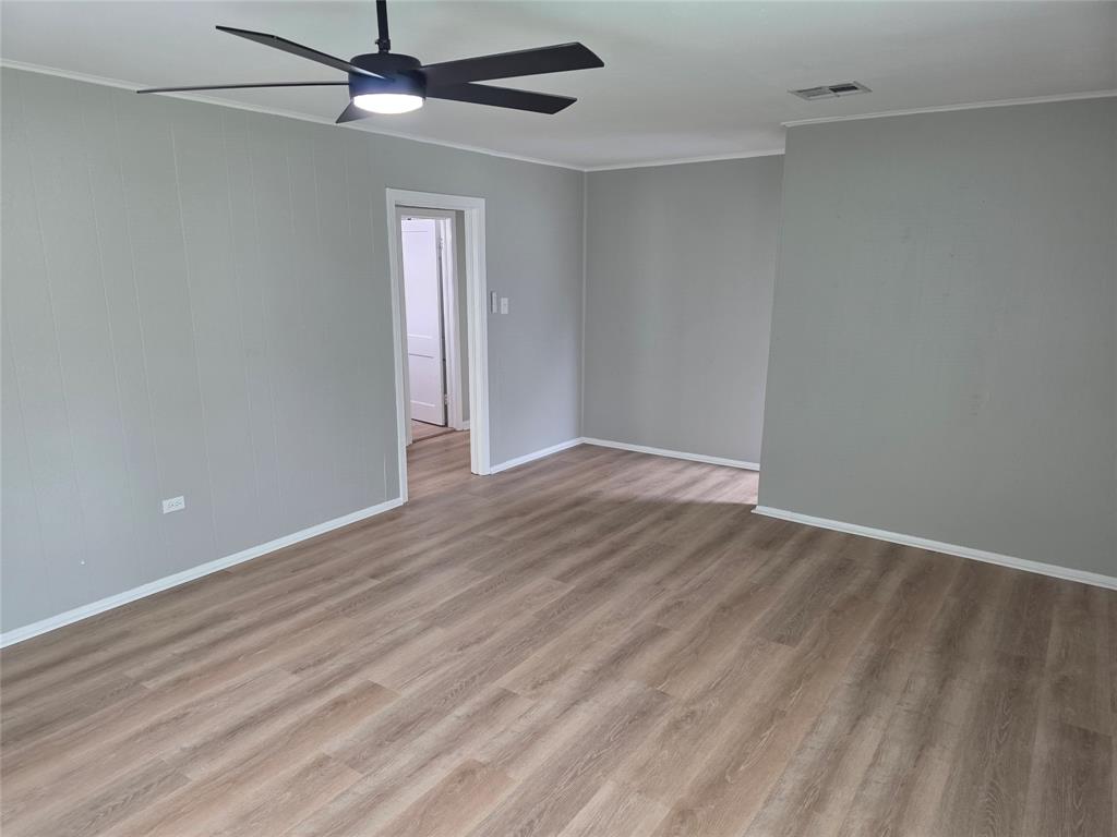2804 Summer Avenue Waco, TX 76708 - Photo 5 of 13 Spacious room featuring light-toned wood-finish flooring, light gray walls, white baseboards, and a modern ceiling fan with integrated lighting