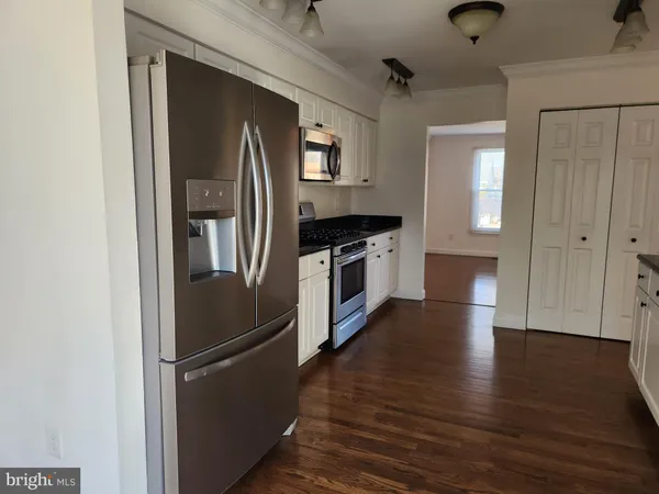 a kitchen with stainless steel appliances a stove a microwave and a hard wood floor