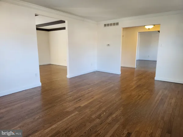 an empty room with wooden floor and a window