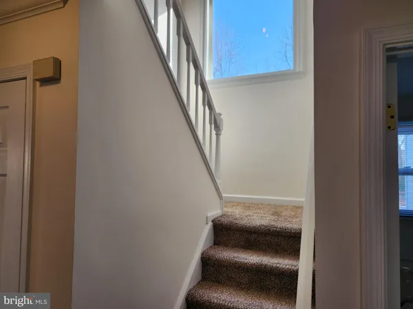 a view of staircase with wooden floor and window