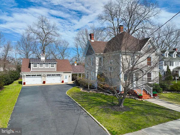 a view of a white house with a big yard and a large tree