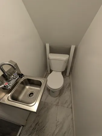 a toilet sitting in a bathroom next to a sink