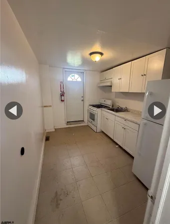 a kitchen with white cabinets and white appliances