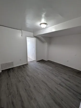 a view of an empty room with wooden floor