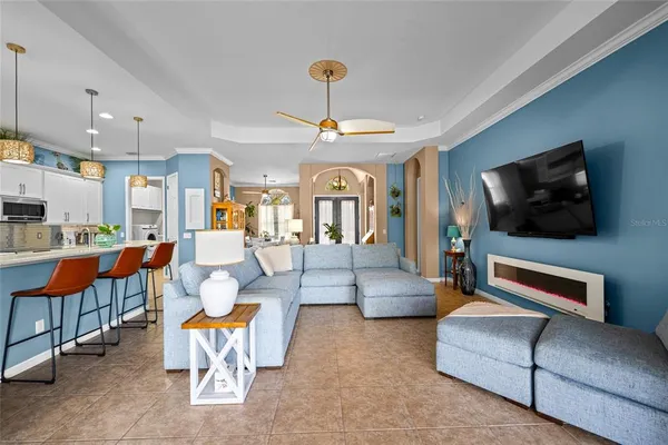 a bedroom with a bed a dresser and a chandelier